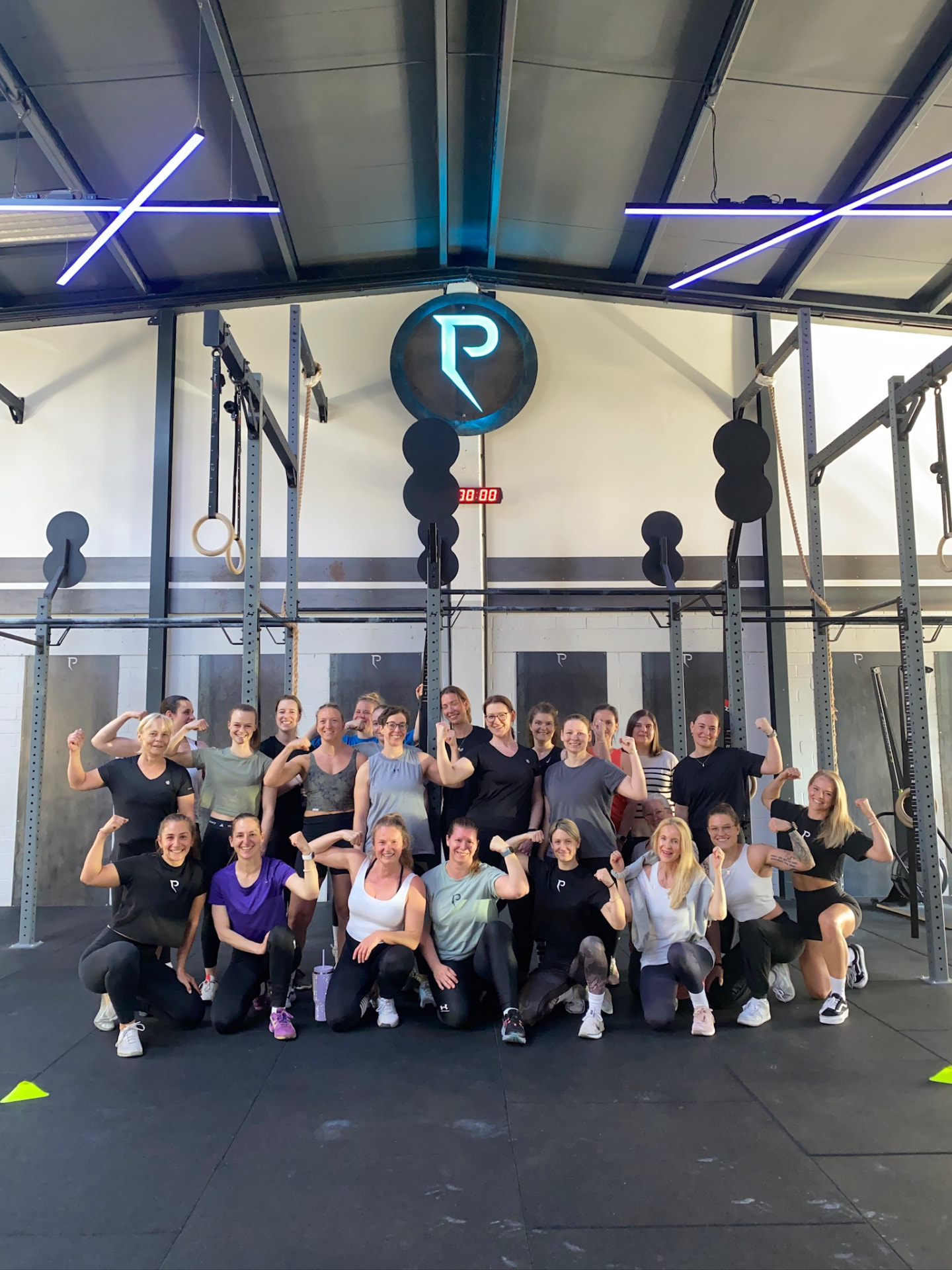 Große Gruppe von Frauen zeigt nach dem Workout ihre Muskeln